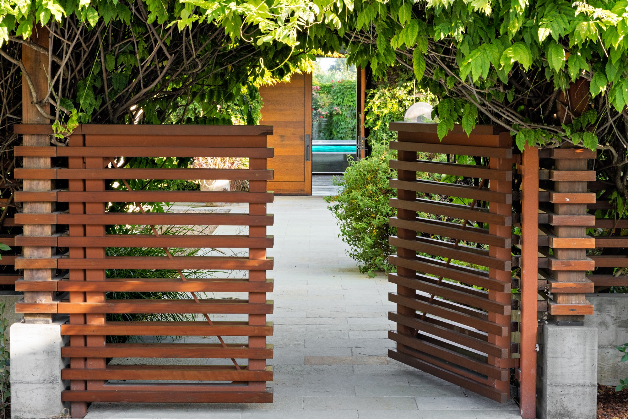 slatted wood doors open to an architectural courtyard with direct views to the outdoor pool
